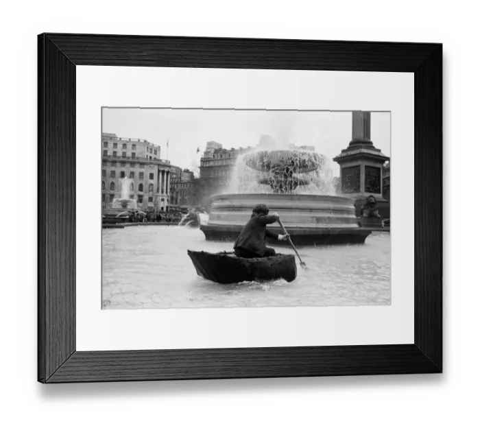 Framed Print : Coracle fishermen in London. One of the fishermen paddles his coracle round Trafalgar