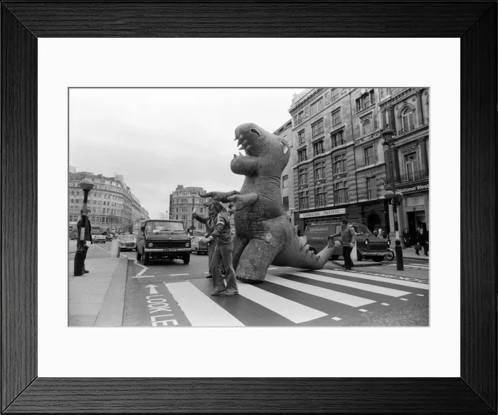Framed Print : Two dinosaurs as high as a double decker bus fight each other in London Framed Print : Two dinosaurs as high as a double decker bus fight each other in London