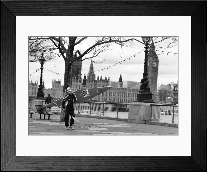 Framed Print : Competitor in the Thames canoe race walks with his boat along the South Bank before Framed Print : Competitor in the Thames canoe race walks with his boat along the South Bank before
