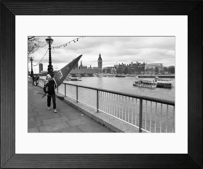 Framed Print : Competitor in the Thames canoe race walks with his boat along the South Bank before Framed Print : Competitor in the Thames canoe race walks with his boat along the South Bank before