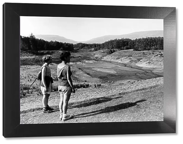 Hikers by the drought effected Neuadd Lower Reservoir, in the Brecon Beacons, South Wales
