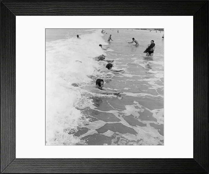 Framed Print : When the foaming waves break with a roar, bathers throw themselves forward onto their