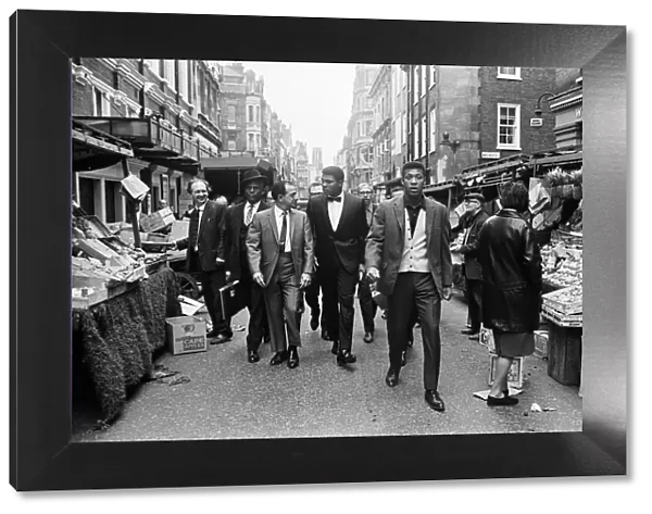 Cassius Clay (centre) and entourage walking through Berwick market on route to his press