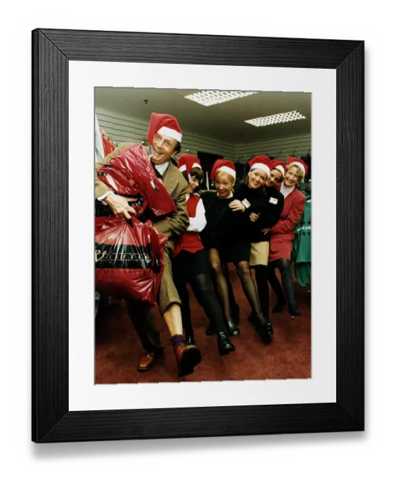 Framed Print : Barry Humphries with staff Weisfeld store Glasgow conga line wearing Snata claus caps