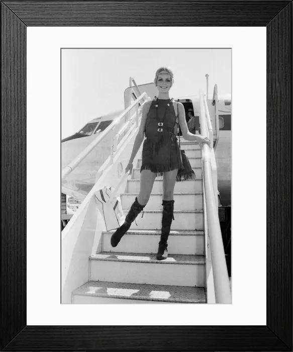 Framed Print : Twiggy, (real name Leslie Hornby) English model, seen in a Hippie gear outfit leaving