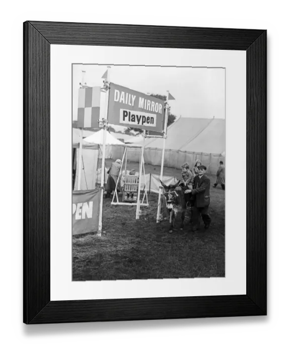 Framed Print : A child riding on a donkey past the Daily Mirror Playpen at Altrincham agriculture show