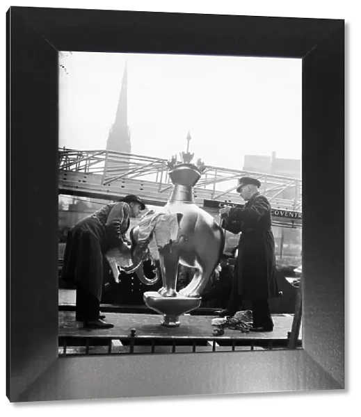 Fireman helps place the Elephant and Castle statue on top of the standard in Broadgate
