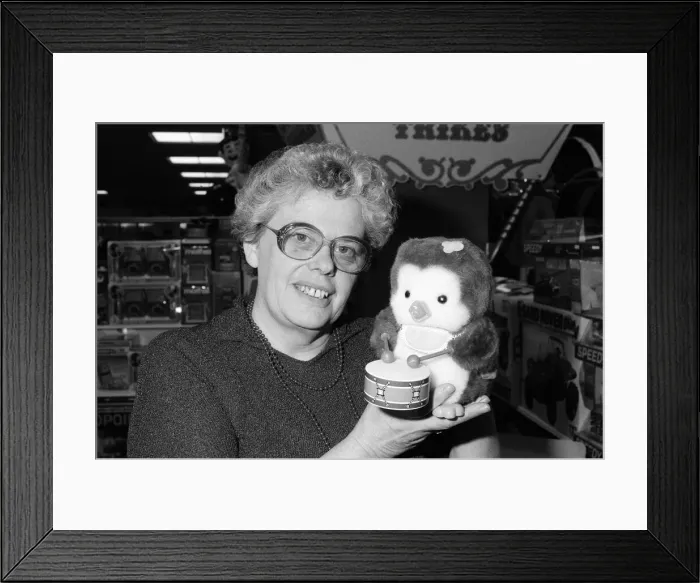 Framed Print : Mrs Beryl Bennington, Rackhams toy department manager, with a drumming penguin toy Framed Print : Mrs Beryl Bennington, Rackhams toy department manager, with a drumming penguin toy