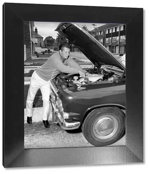 Actor Johnny Briggs fixing his car at home. Circa 1963