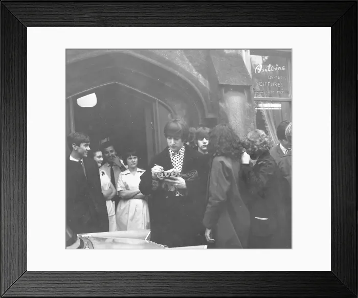Framed Print : John Lennon, with Ringo Starr behind him, signs an autograph for a Beatles fan outside