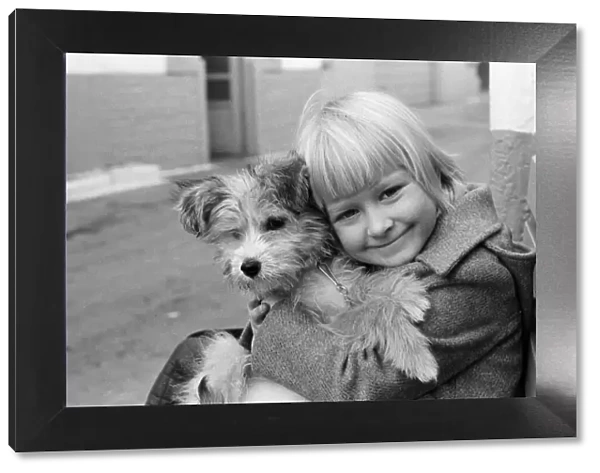 A young girl holding her puppy, Scamp. 2nd January 1980