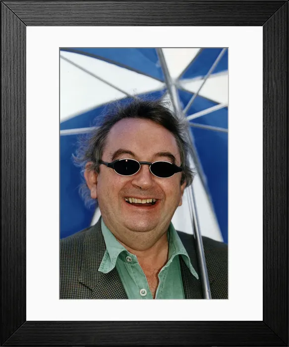 Framed Print : Ian McCaskill wearing a pair of BHS Ultraviolet Protection Sunglasses holding umbrella