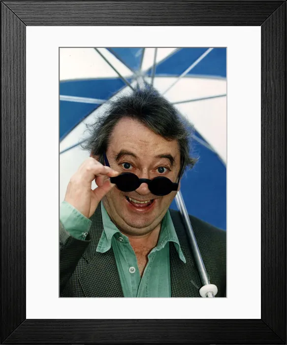 Framed Print : Ian McCaskill Peering over the rim of a pair of sunglasses holding umbrella C / photo Framed Print : Ian McCaskill Peering over the rim of a pair of sunglasses holding umbrella C / photo