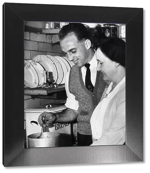 Liverpool full back Ronnie Moran sampling the cooking of his mum in the kitchen at home