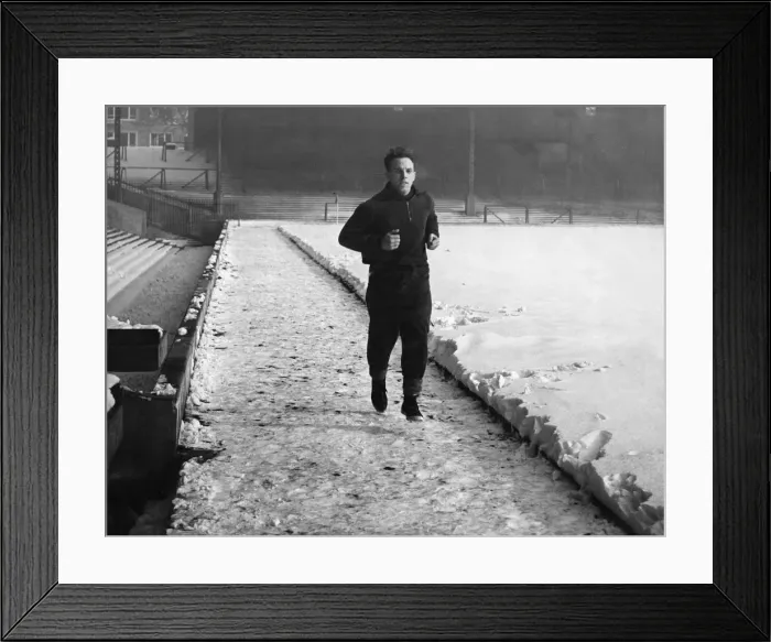 Framed Print : Liverpool full back Ronnie Moran putting in a spot of training despite conditions