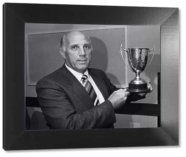 Liverpool coach Ronnie Moran holds the Dixie Dean Memorial trophy after nearly forty