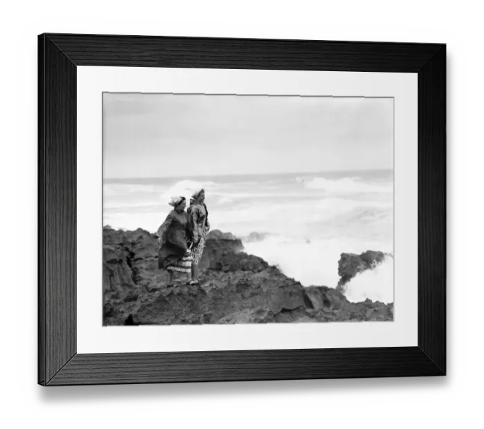Framed Print : Two women standing on rocks by the sea at Coney Beach, Porthcawl, Mid Glamorgan, Wales