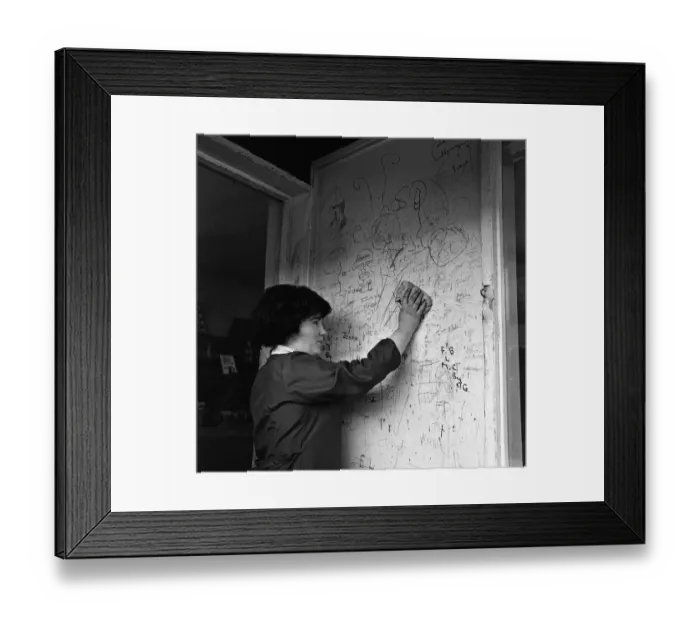 Framed Print : A shop assistant removes the scribbling on the wall outside her shop in Kirkby, Liverpool Framed Print : A shop assistant removes the scribbling on the wall outside her shop in Kirkby, Liverpool