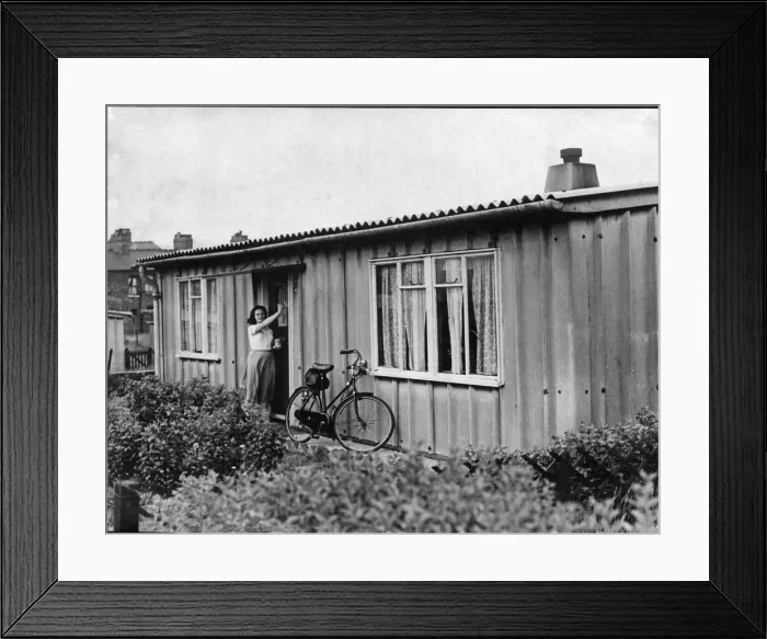 Framed Print : Prefab Bungalows Prefab Housing. A young lady rests her bicycle