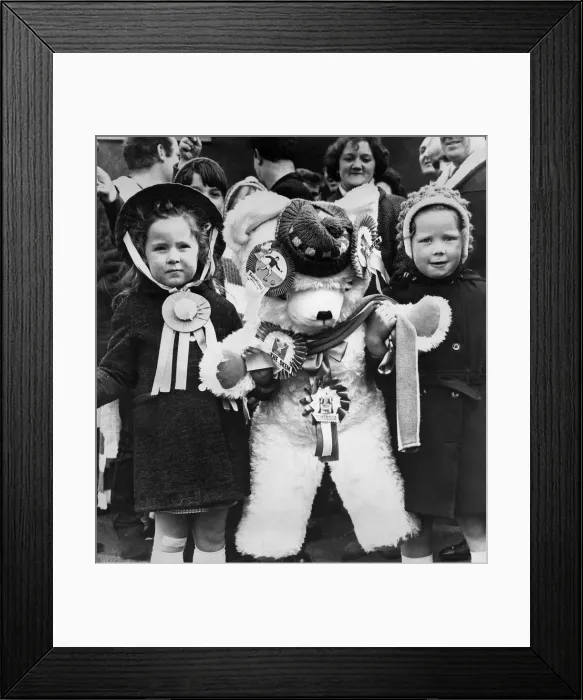 Framed Print : Young female fans of Skelmersdale Football club holding a giant mascot teddy bear as they