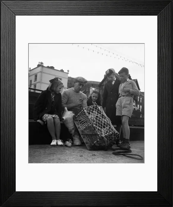Framed Print : Children watching a fisherman at work with his net. North Yorkshire coast Framed Print : Children watching a fisherman at work with his net. North Yorkshire coast