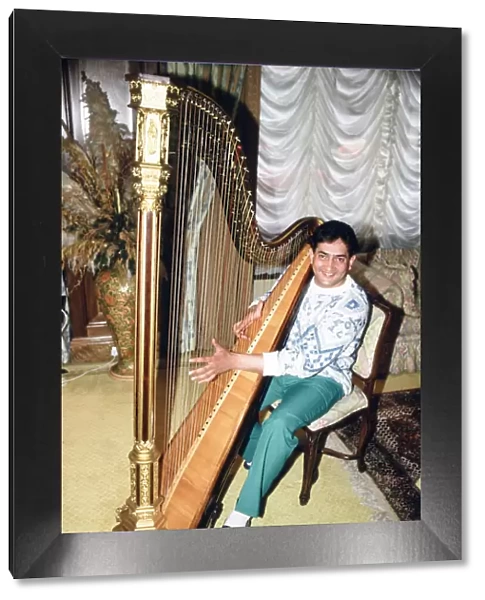 World snooker champion Joe Johnson poses in London, playing a harp. 28th May 1986
