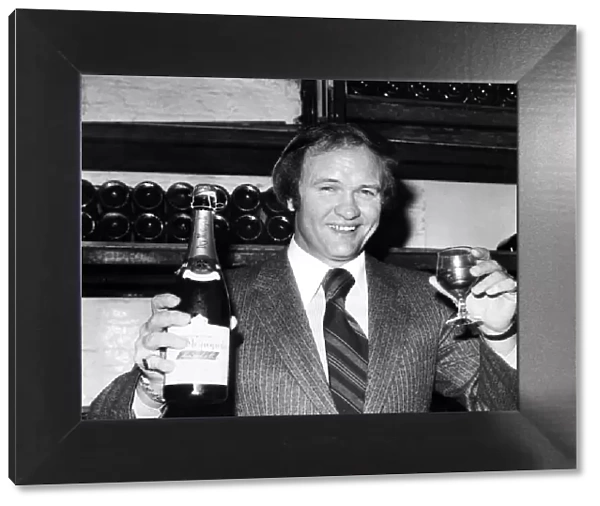 West Bromwich Albion football manager Ron Atkinson holds up a bottle of champagne at