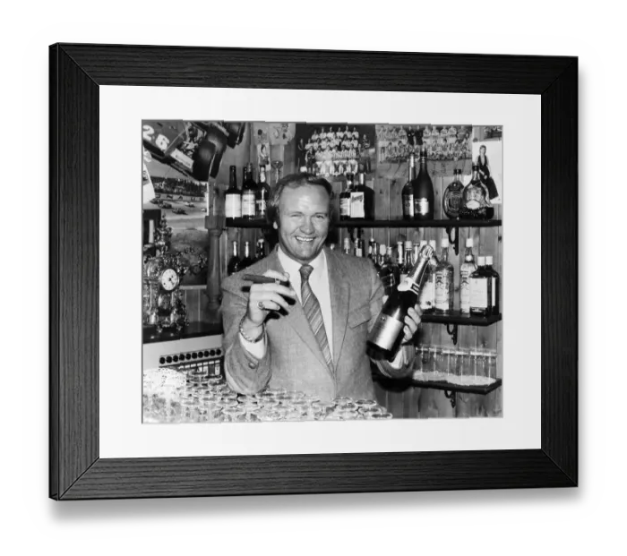 Framed Print : New Manchester United football manager Ron Atkinson holds up a bottle of champagne in one Framed Print : New Manchester United football manager Ron Atkinson holds up a bottle of champagne in one