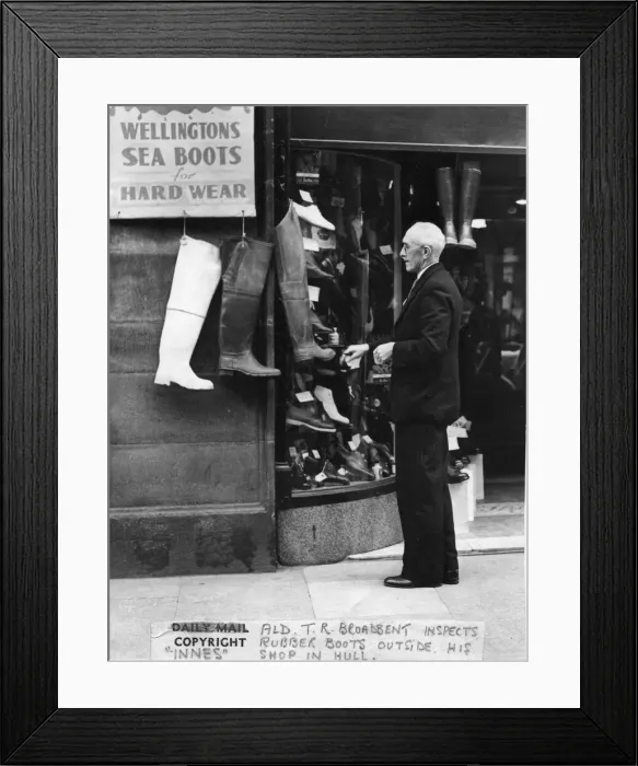 Framed Print : May 1950. Alderman TR Broadbent looking at a shop display of boots outside a shop by Framed Print : May 1950. Alderman TR Broadbent looking at a shop display of boots outside a shop by