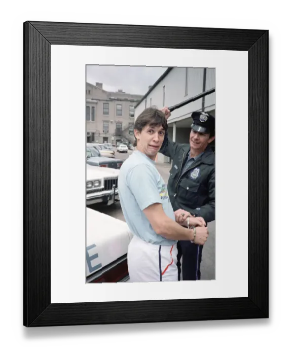 Framed Print : England football star Gary Lineker, is handcuffed by a police officer during a visit to a Framed Print : England football star Gary Lineker, is handcuffed by a police officer during a visit to a