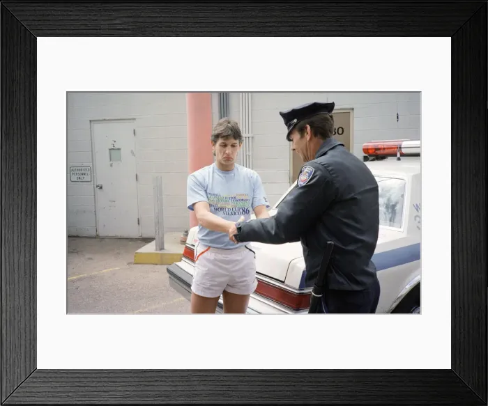 Framed Print : England football star Gary Lineker, is handcuffed by a police officer during a visit to a Framed Print : England football star Gary Lineker, is handcuffed by a police officer during a visit to a