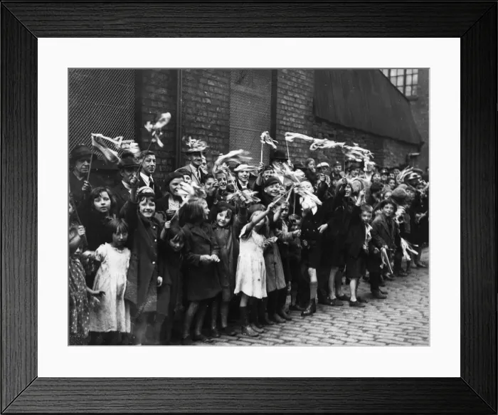 Framed Print : Local children wave their flags and cheer in Craven Street during the visit of the Duke