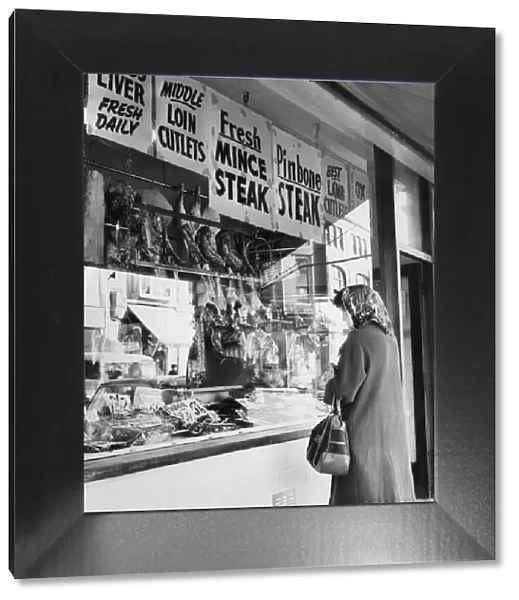 Woman looking through window of butchers shop, Cardiff, Wales, 2nd October 1967