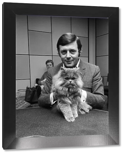 BBC commentator Michael Aspel at the BBC Studios at Lancaster Gate with a cat who is a