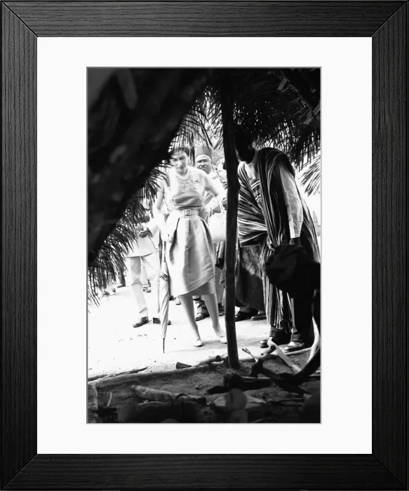 Framed Print : Queen Elizabeth looks in on one of the village huts during a visit to Hangha in Kenema Framed Print : Queen Elizabeth looks in on one of the village huts during a visit to Hangha in Kenema