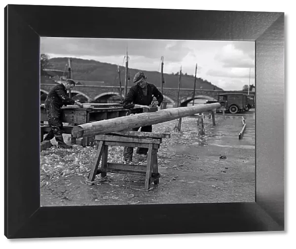 Carpenters seen here making a new mast for a fishing boats moored in the Cornish fishing