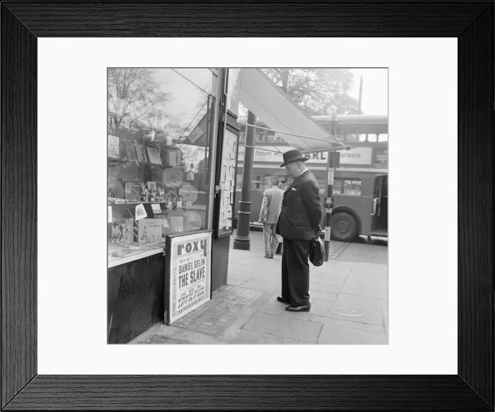 Framed Print : Gentleman looking at local classified and personal adverts on notice board outside shop