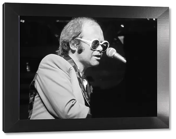 Elton John performing on stage, during the Elton John and Ray Cooper concert tours
