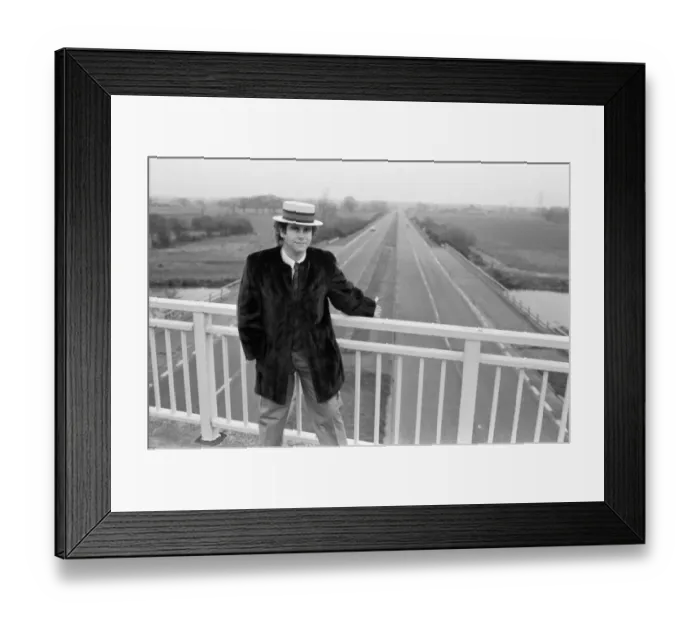 Framed Print : Elton John pictured standing on a bridge over the motorway. 5th December 1982 Framed Print : Elton John pictured standing on a bridge over the motorway. 5th December 1982