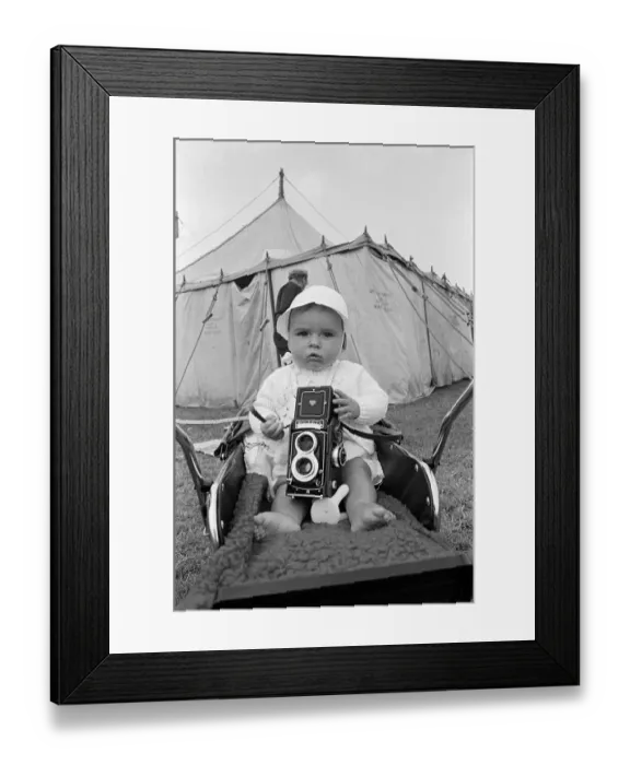 Framed Print : A baby sitting with a Rolleiflex camera at Skelton annual baby show. Circa 1973 Framed Print : A baby sitting with a Rolleiflex camera at Skelton annual baby show. Circa 1973