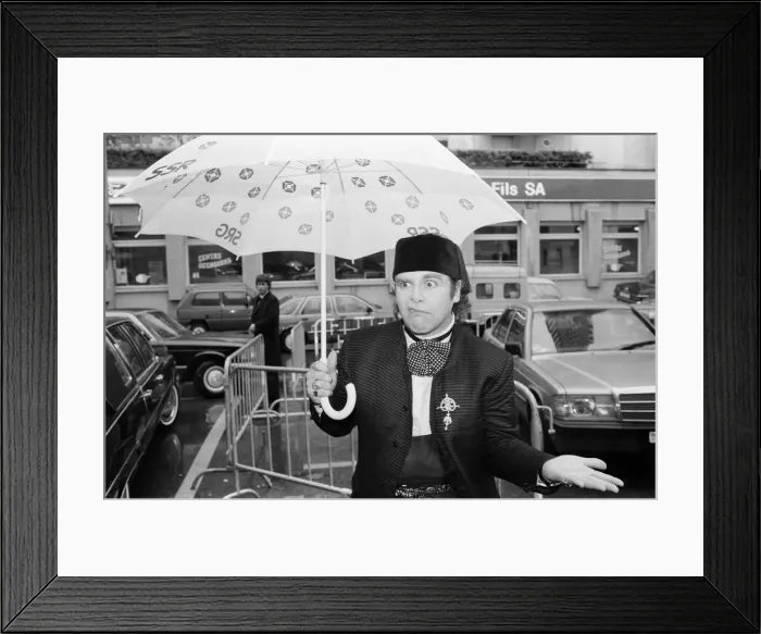 Framed Print : Elton John standing in the rain. He is in Montreux to perform at the Montreux Pop