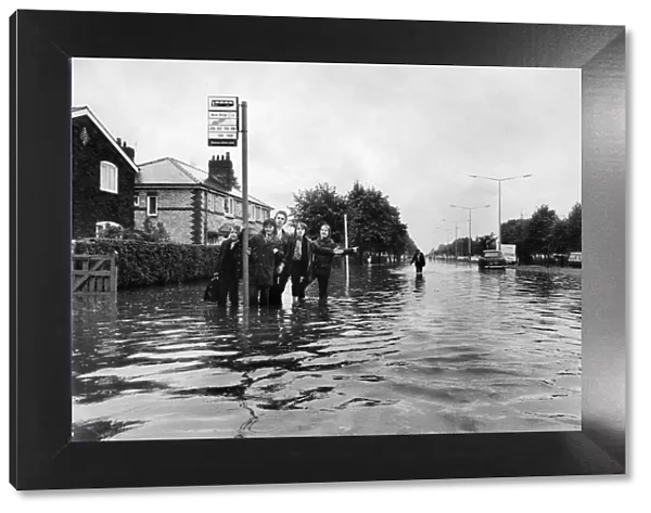 Manchester Schoolboys waiting for the next bus on the flooded Kingsway Road in Burnage