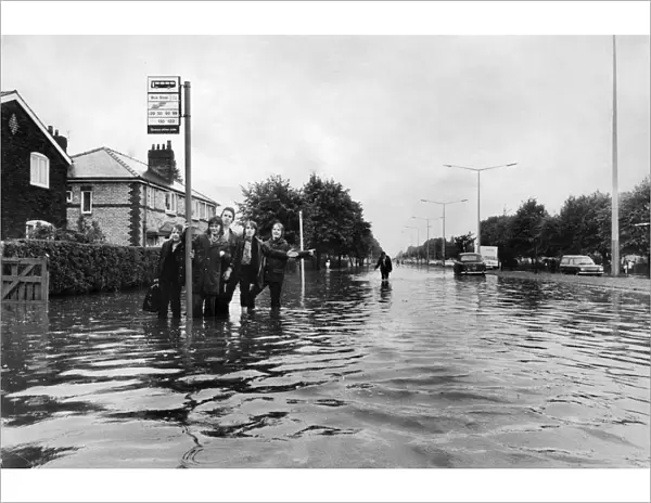 Manchester Schoolboys waiting for the next bus on the flooded Kingsway Road in Burnage