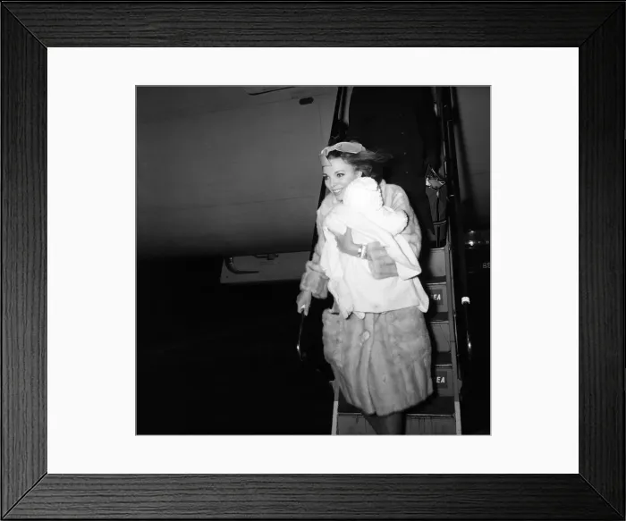 Framed Print : Joan Collins arriving by British European Airways from Paris with her daughter Tara