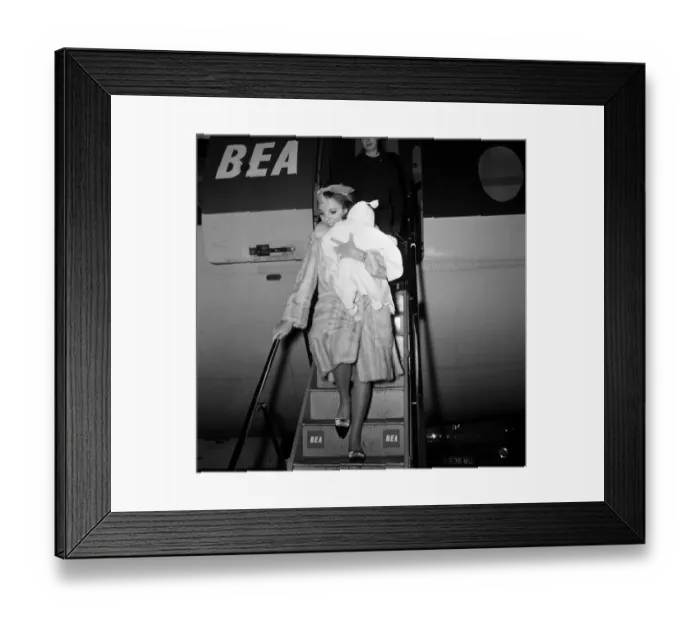 Framed Print : Joan Collins arriving by British European Airways from Paris with her daughter Tara