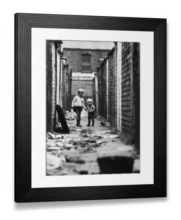 Framed Print : Young children play in the back alleyways behind Clifton Street in Ordsall, Salford