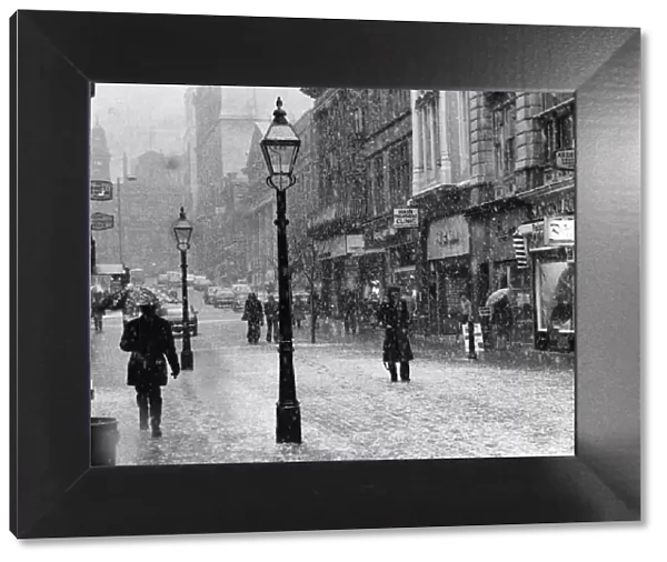 General view of King Street in the snow in Central Manchester with pedestrians walking
