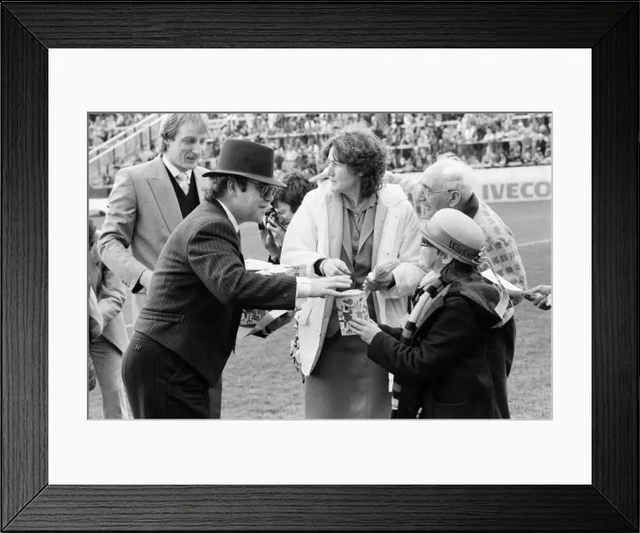 Framed Print : Pop star and Watford FC Chairman, Elton John, handing out Easter eggs to fans Framed Print : Pop star and Watford FC Chairman, Elton John, handing out Easter eggs to fans