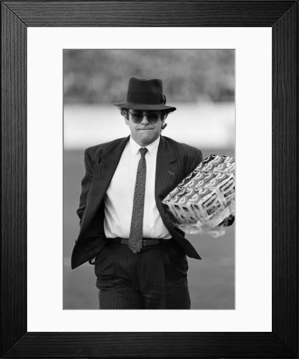 Framed Print : Pop star and Watford FC Chairman, Elton John, handing out Easter eggs to fans Framed Print : Pop star and Watford FC Chairman, Elton John, handing out Easter eggs to fans