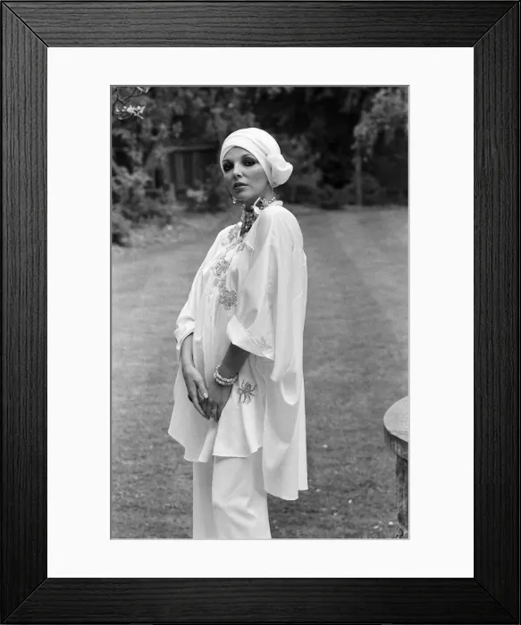 Framed Print : Actress Joan Collins modelling outfits that she will wear on a trip to Tokyo to judge a
